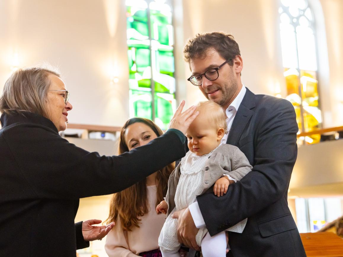 Ein Kleinkind wird getauft